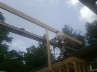 Carpenter setting a ridge beam over a new addition frame — Ice Dam Removal by Roofing Brothers in Donaldson