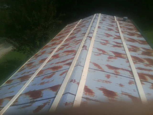 Rusted metal roof panels with new wood purlins before replacement — Storm Damage Roof Repair in Donaldson by Roofing Brothers