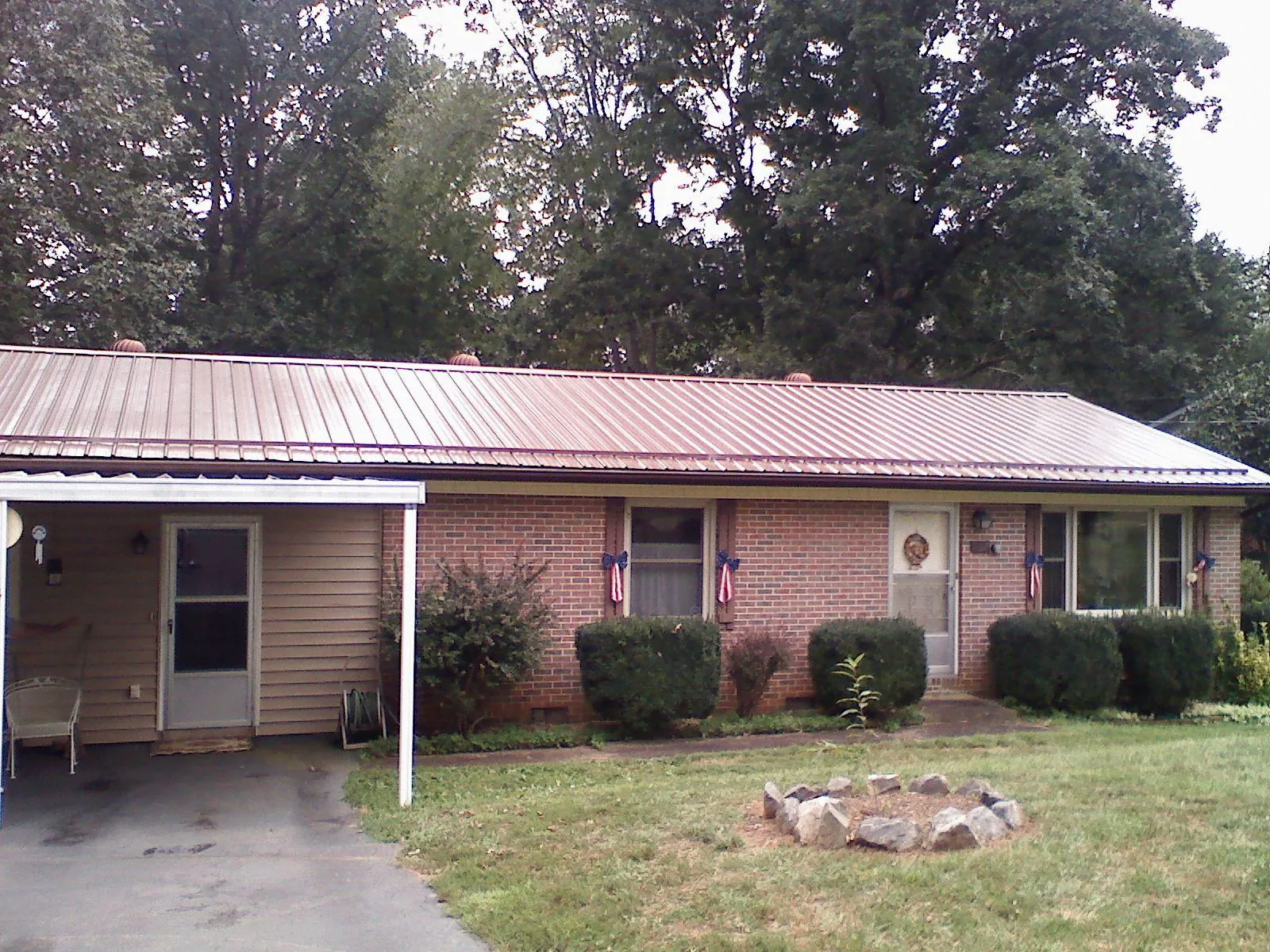 Bronze metal roof and carport on a brick ranch home — Roof Repair work by our crew in Donaldson