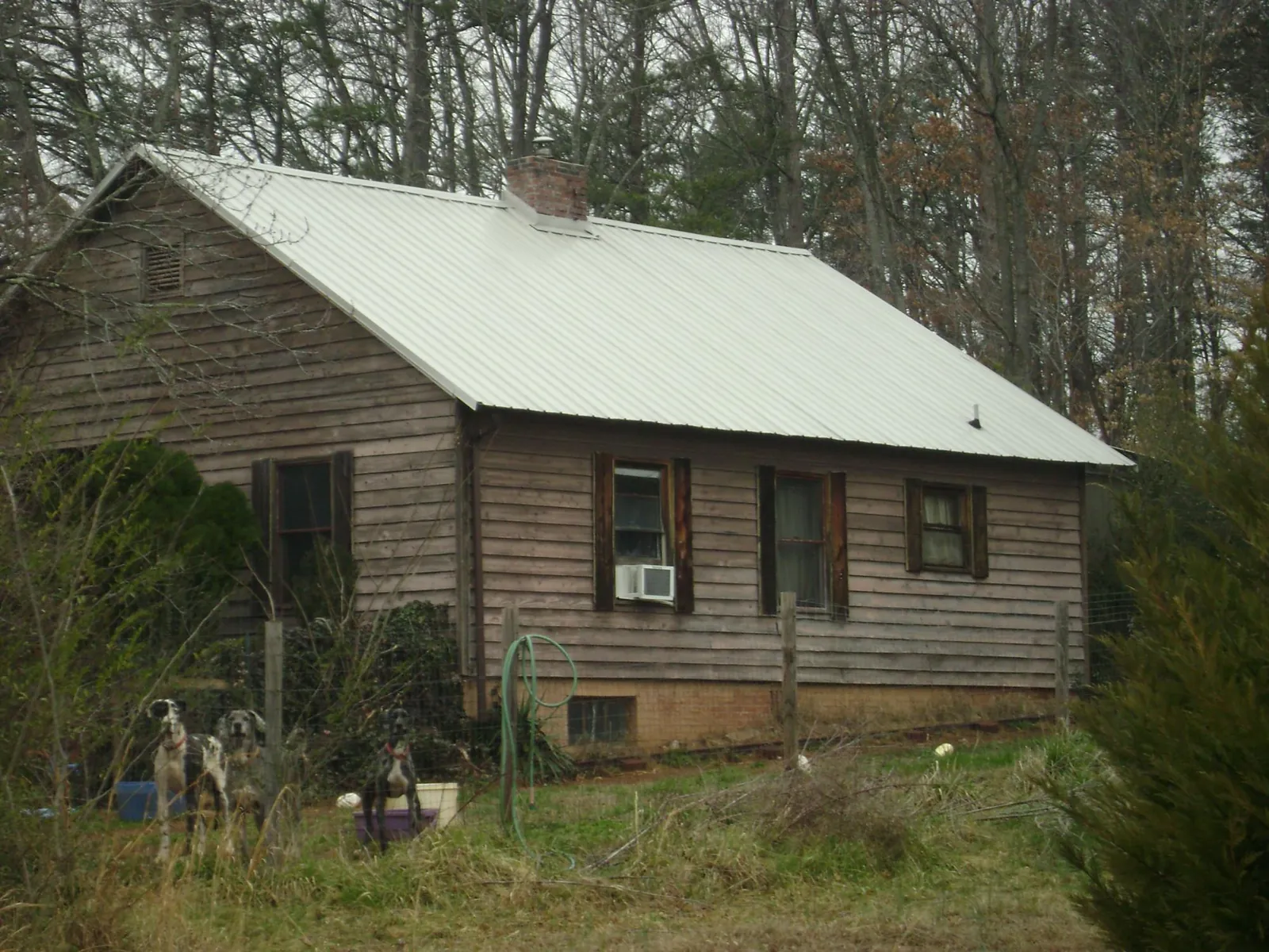 White metal roof on an old wood sided farmhouse, from a Metal Roof Installation job in Donaldson